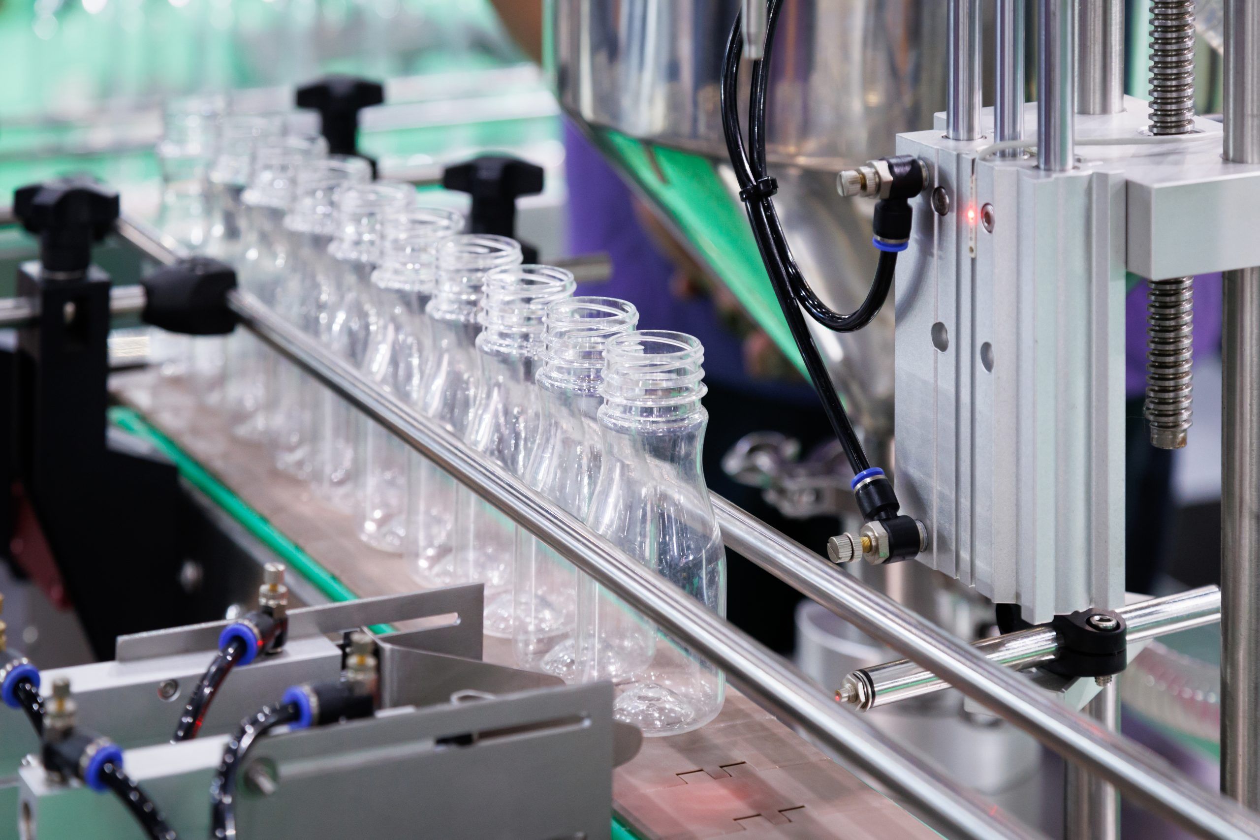 Clear plastic drinking water bottle moving on conveyor belt into